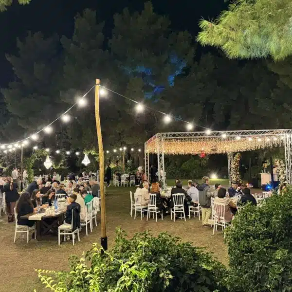 Γάμοι Δεξίωση γάμου σε κήπο το βράδυ στη Θεσσαλονίκη με κρεμαστά string lights και τραπέζια καλεσμένων