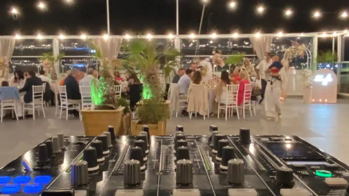 Κονσόλα DJ σε δεξίωση γάμου με φωτάκια και θέα στη θάλασσα