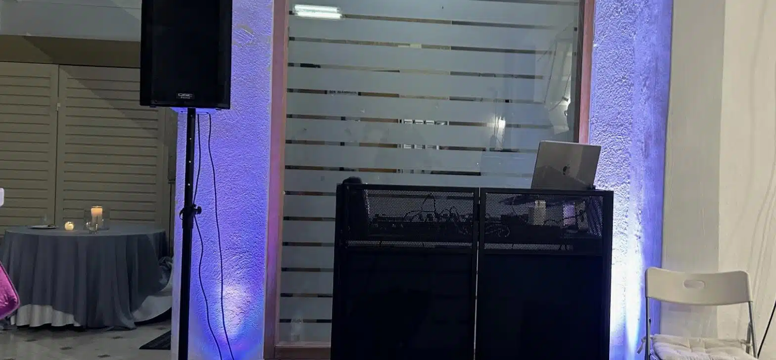 Ηχείο σε βάση και κονσόλα DJ με φωτισμό τοίχου σε αίθουσα εκδήλωσης