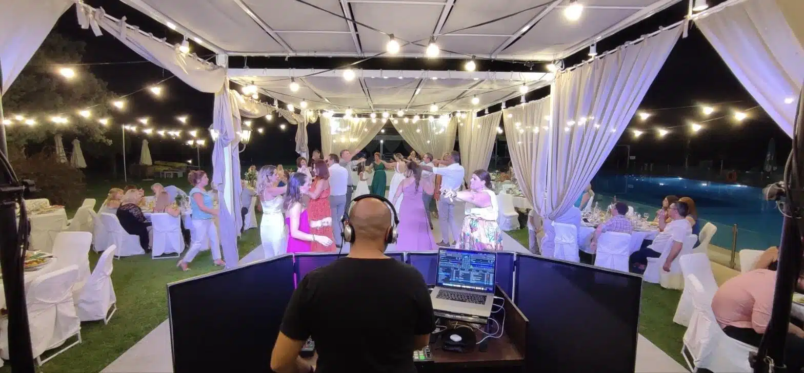 DJ γάμου πίσω από την κονσόλα σε βραδινή δεξίωση με γεμάτη πίστα DJ γάμου πίσω από την κονσόλα σε βραδινή δεξίωση με γεμάτη πίστα
